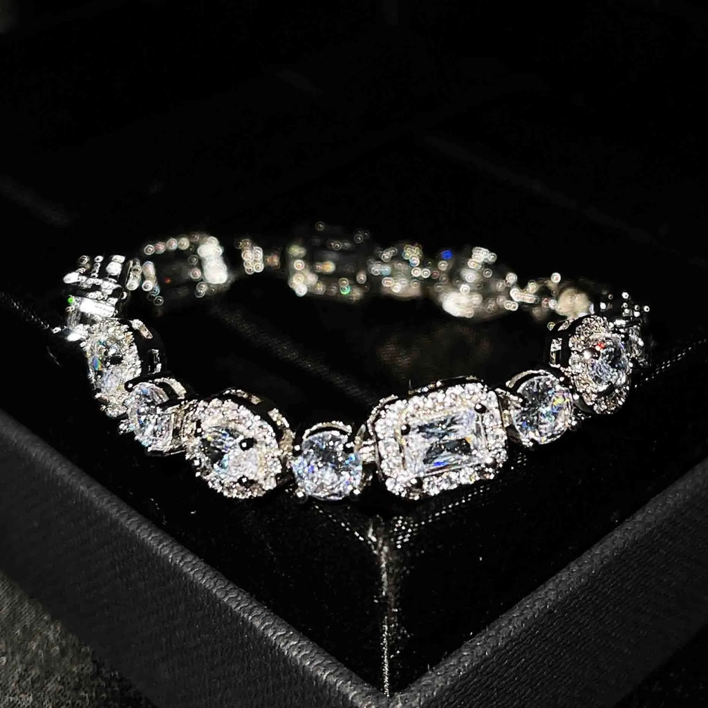 Women's geometric silver bracelet with zircon stones on a white background.