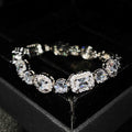 Women's geometric silver bracelet with zircon stones on a white background.