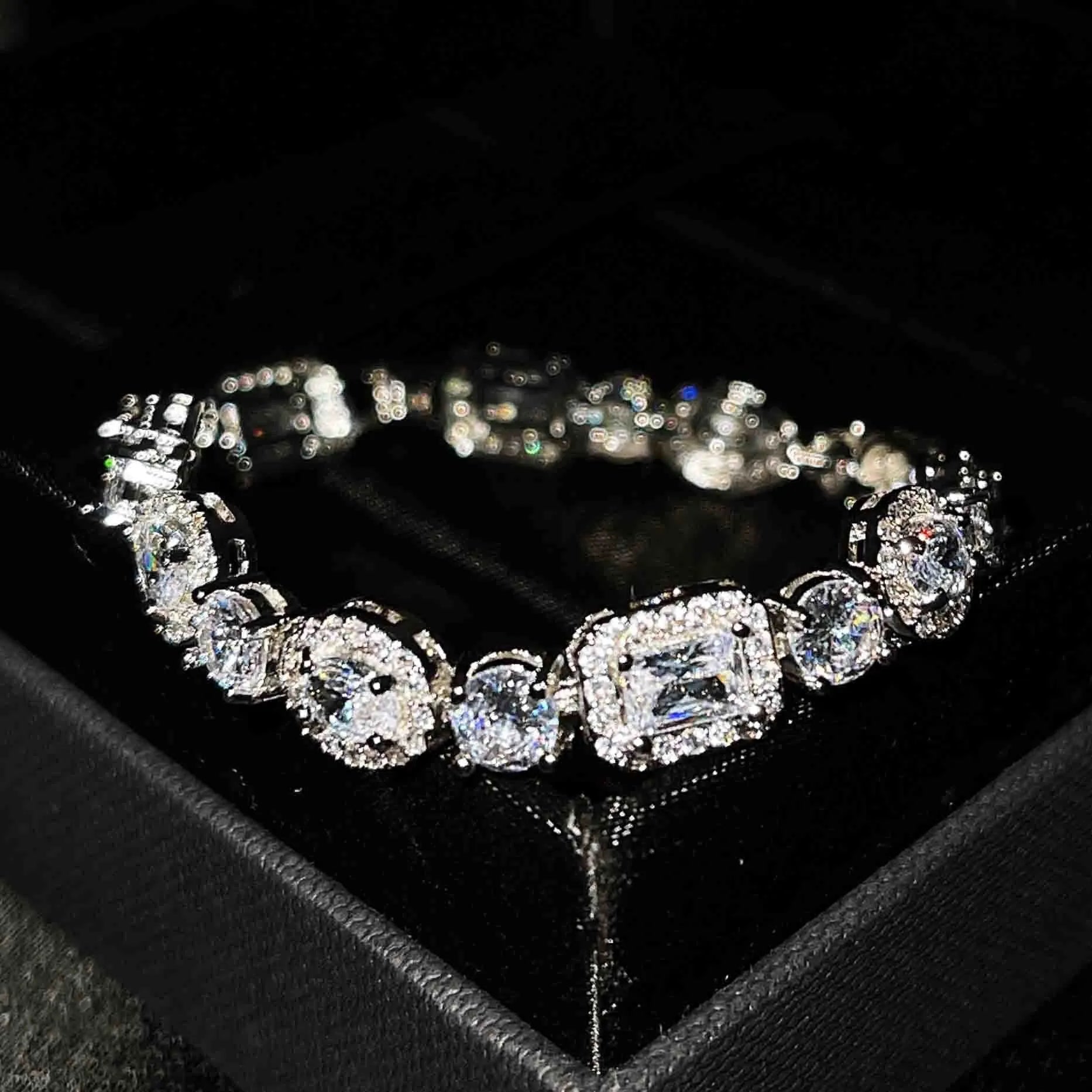 Women's geometric silver bracelet with zircon stones on a white background.
