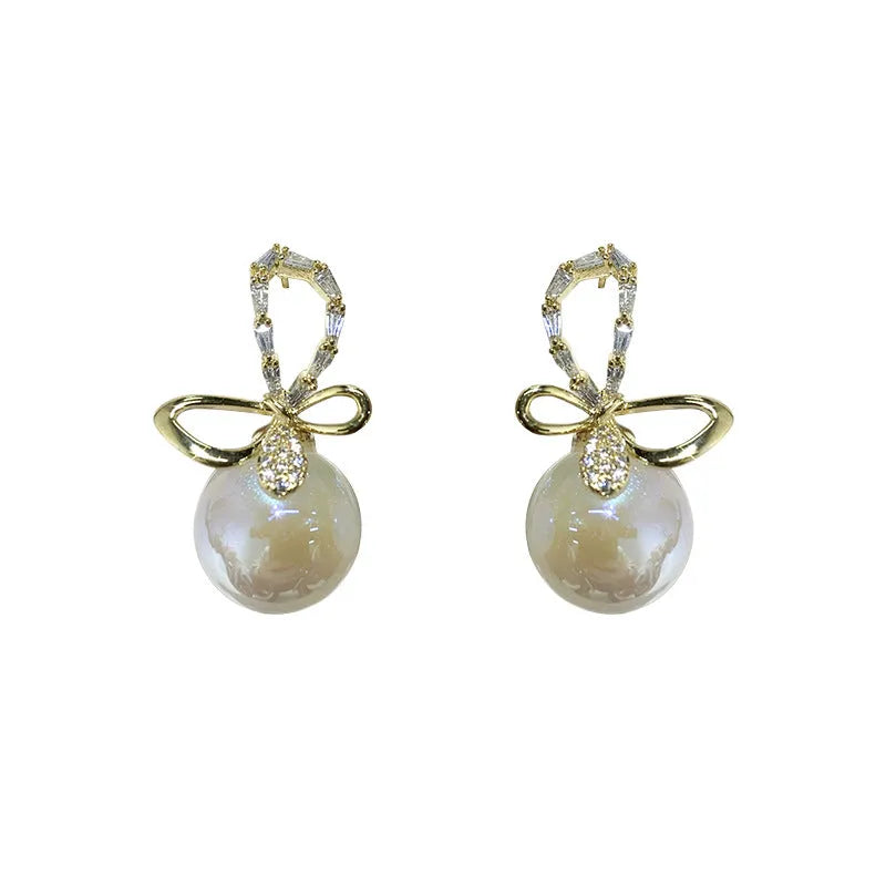 Pair of minimally designed gold tone drop earrings with single faux pearl