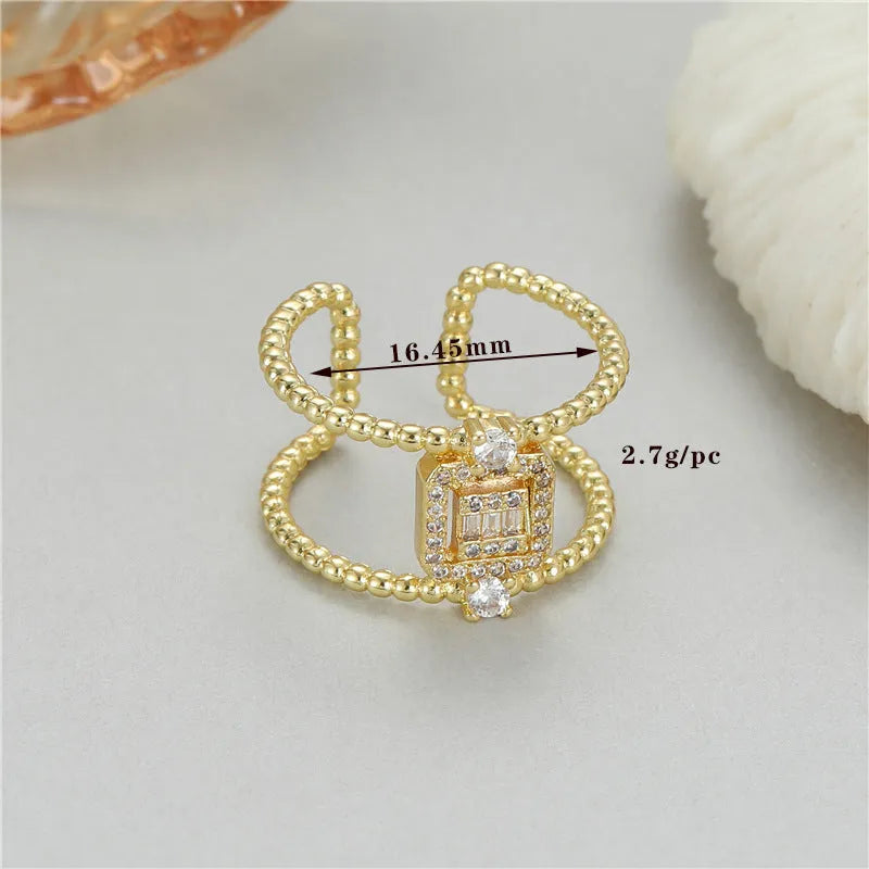 Gold-coloured asymmetric U-shaped open ring with an adjustable opening on a neutral background.