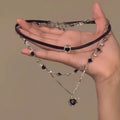 Close-up of a women's multi-layer heart necklace with a leather pendant on an adjustable alloy chain.