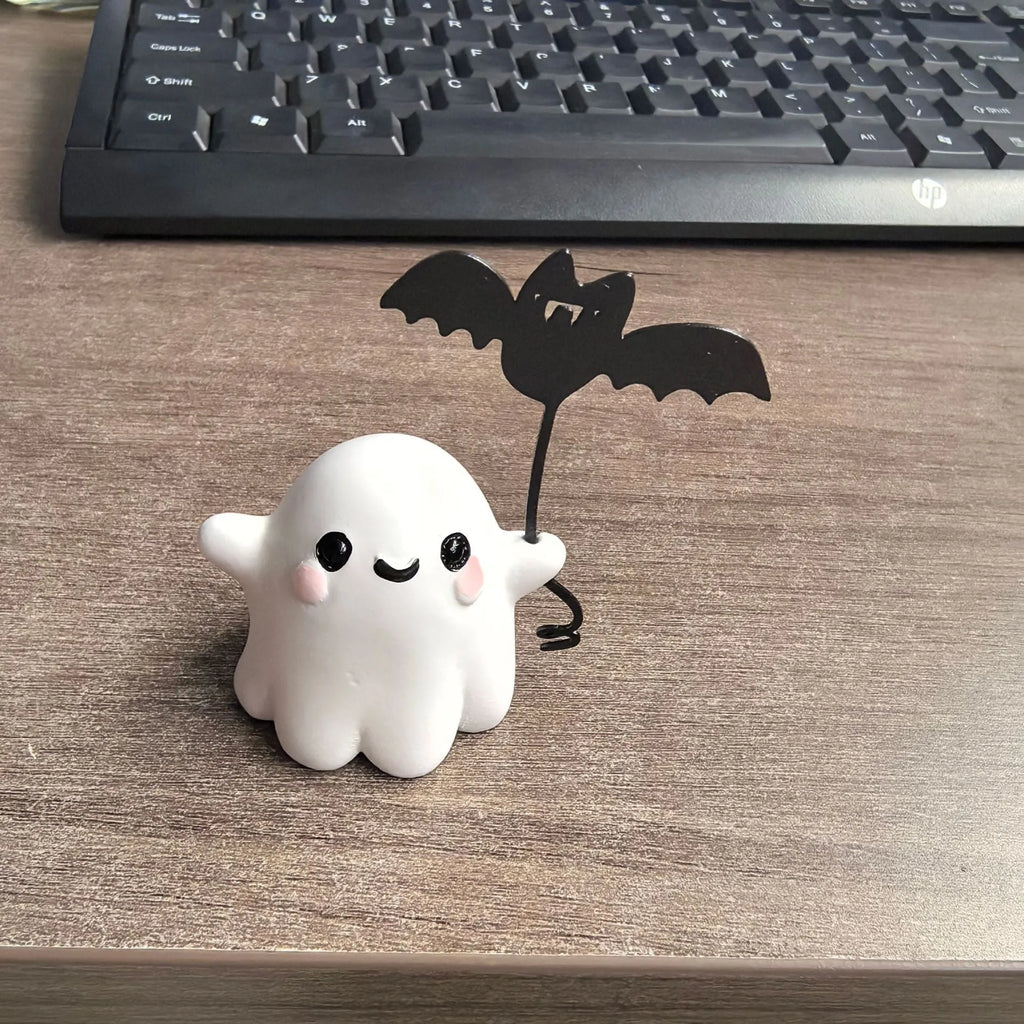 Small resin statue of an American-style ghost walking a dog and holding a bat.