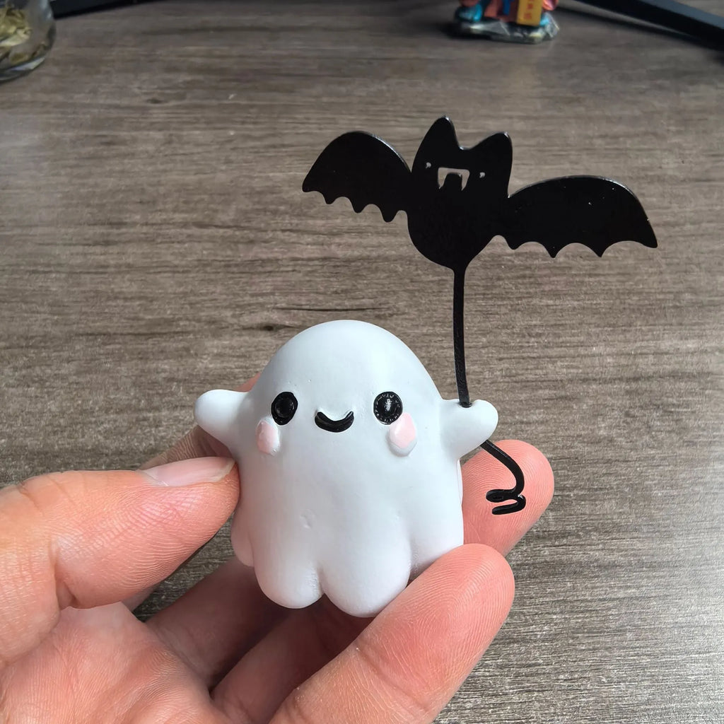 Small resin statue of an American-style ghost walking a dog and holding a bat.
