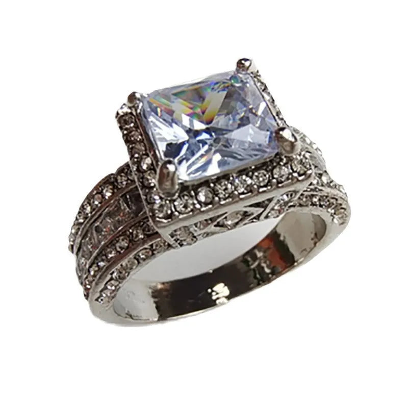 Geometric silver fashion ring for women in gold or white colour on a grey background.