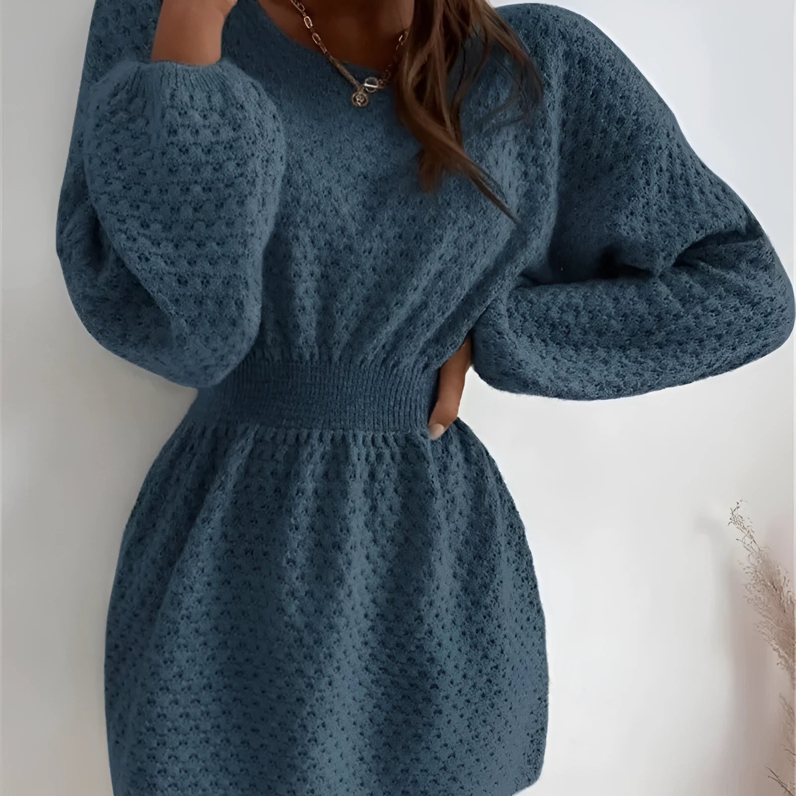 Blue women's knitted dress with crochet flower detail and a fitted waist.