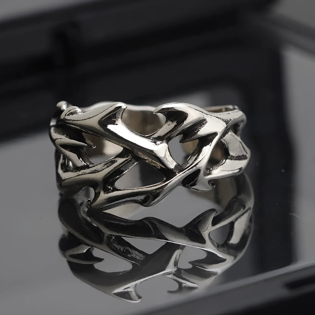 Copper adjustable ring with geometric thorn and flower design on a hand.