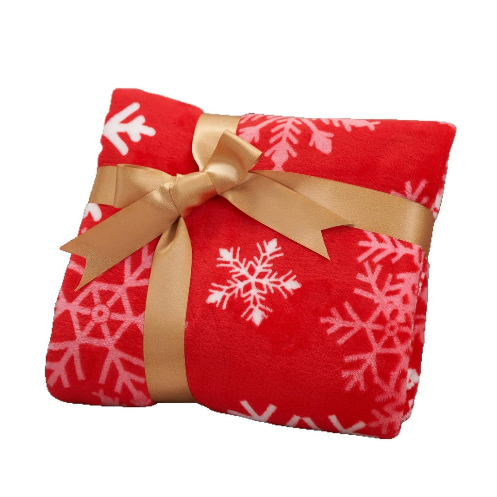 Soft red plush Christmas blanket draped over a sofa corner.
