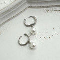 A pair of women's alloy earrings with a geometrical shape and a central round pearl.