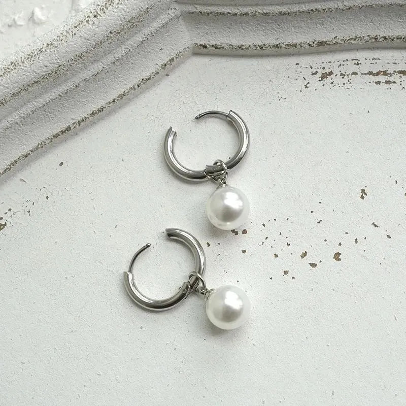 A pair of women's alloy earrings with a geometrical shape and a central round pearl.