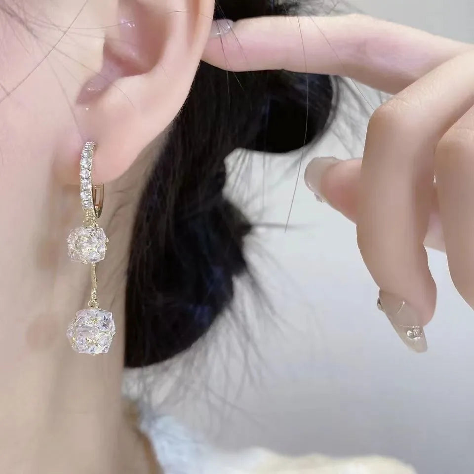 Silver drop earrings for women with a tassel ball and rhinestone ball pendant design.