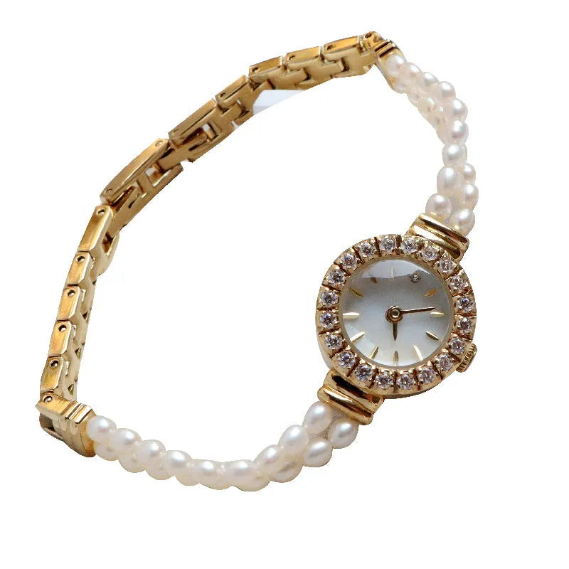 Women's light gold bracelet watch with natural freshwater pearls on a stainless steel strap, showing the 18mm round dial.