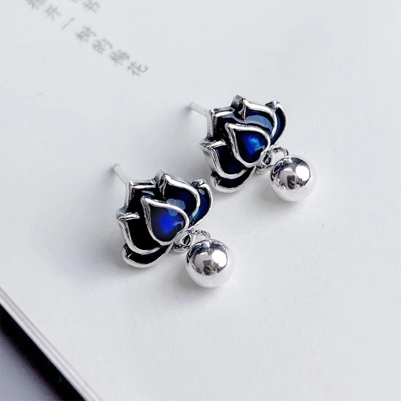 Blue lotus flower ear studs with seedpod tassel detail, silver alloy construction.