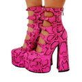 Black patent leather women's platform high heels with a thick heel and a serpentine buckle strap across the foot.