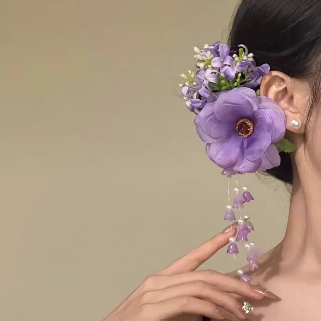 Yellow flower with tassel decorative side clip hair accessory on white background.