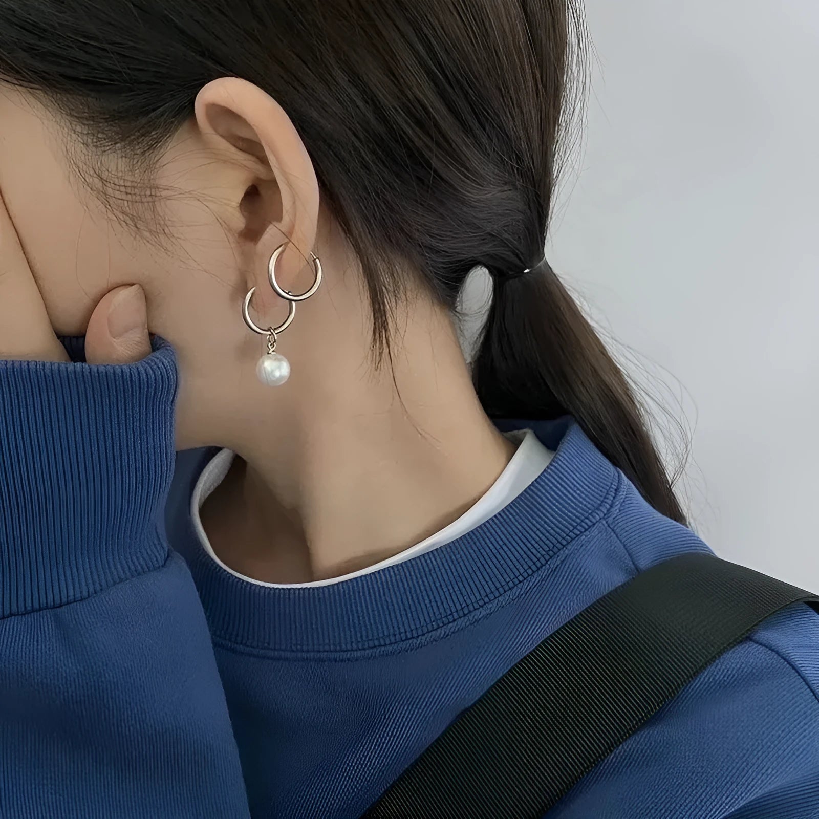 A pair of women's alloy earrings with a geometrical shape and a central round pearl.