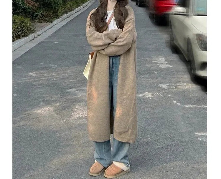 Woman wearing a loose, thick-knit chenille cardigan in a solid colour, showing the long sleeves and casual fit.
