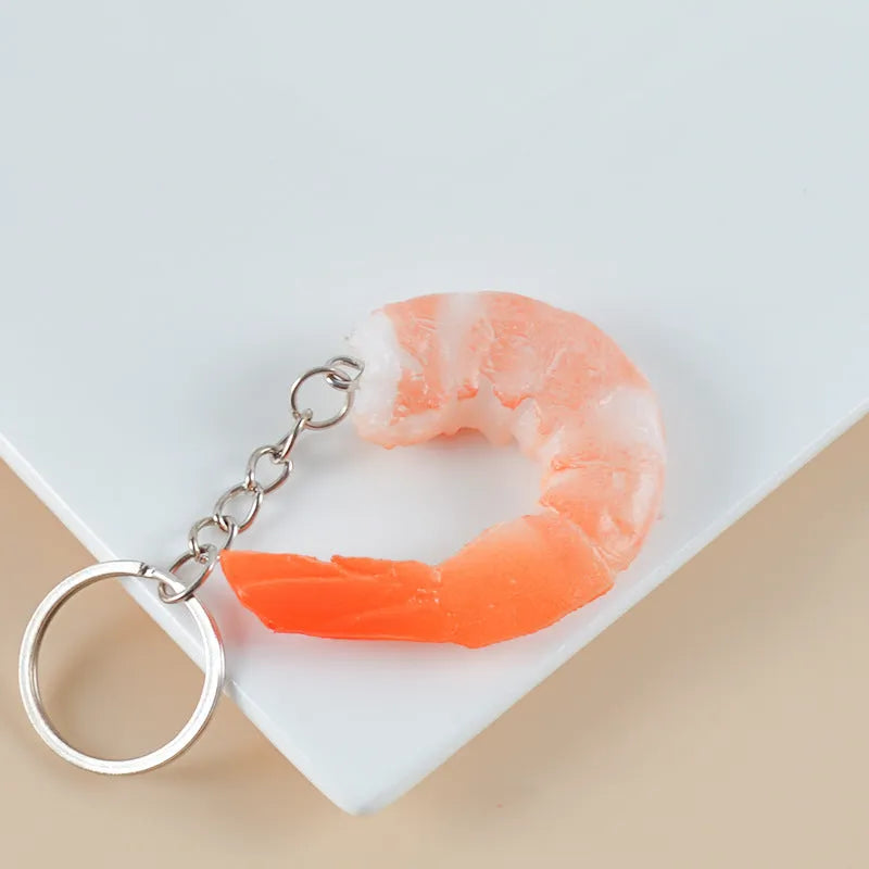 PVC shrimp-shaped keychain with metal door buckle, showing detailed crustacean design.