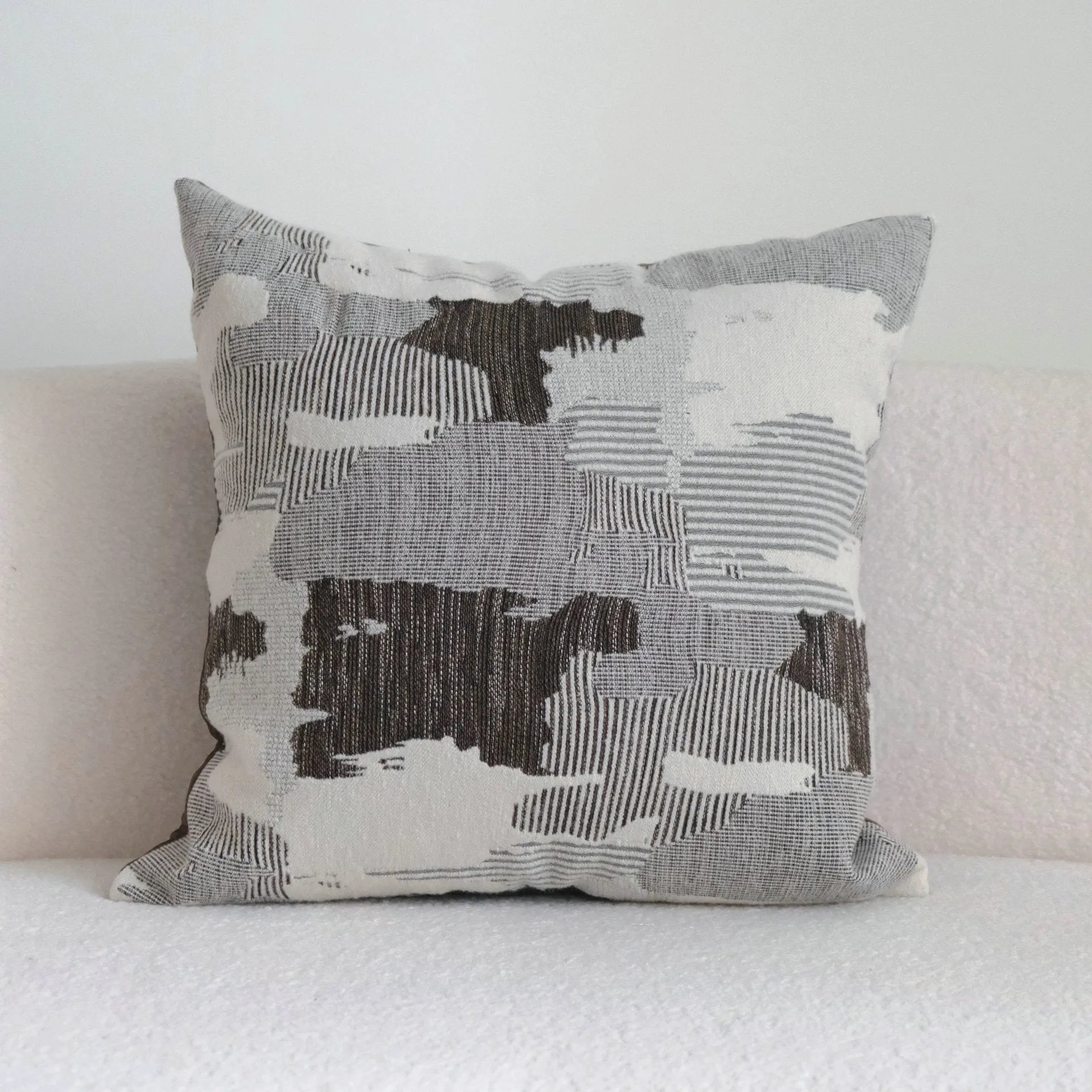 Coffee brown Chinese classical style cushion with striped and patchwork designs on a sofa.