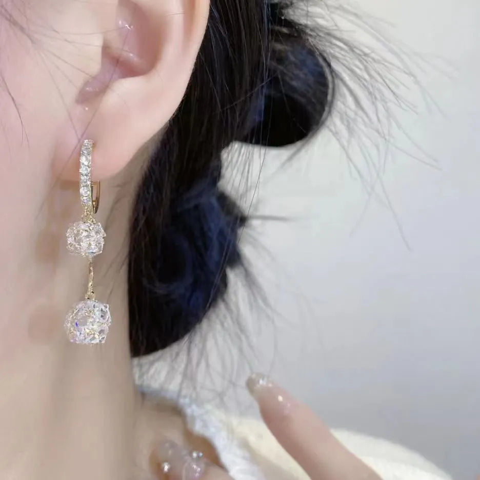 Silver drop earrings for women with a tassel ball and rhinestone ball pendant design.