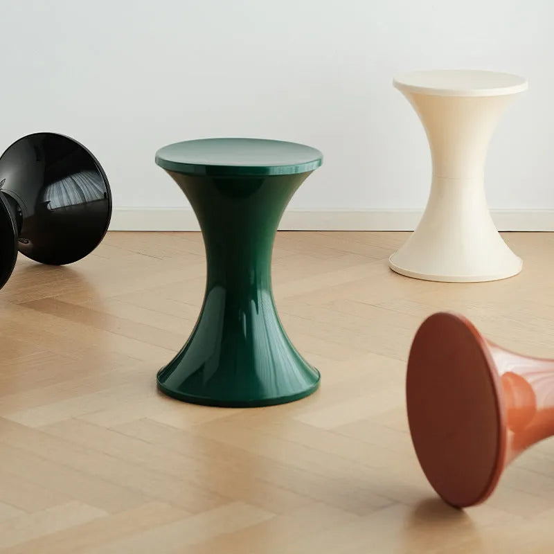 Creative hourglass-shaped plastic stool for changing shoes, shown in a green colour.