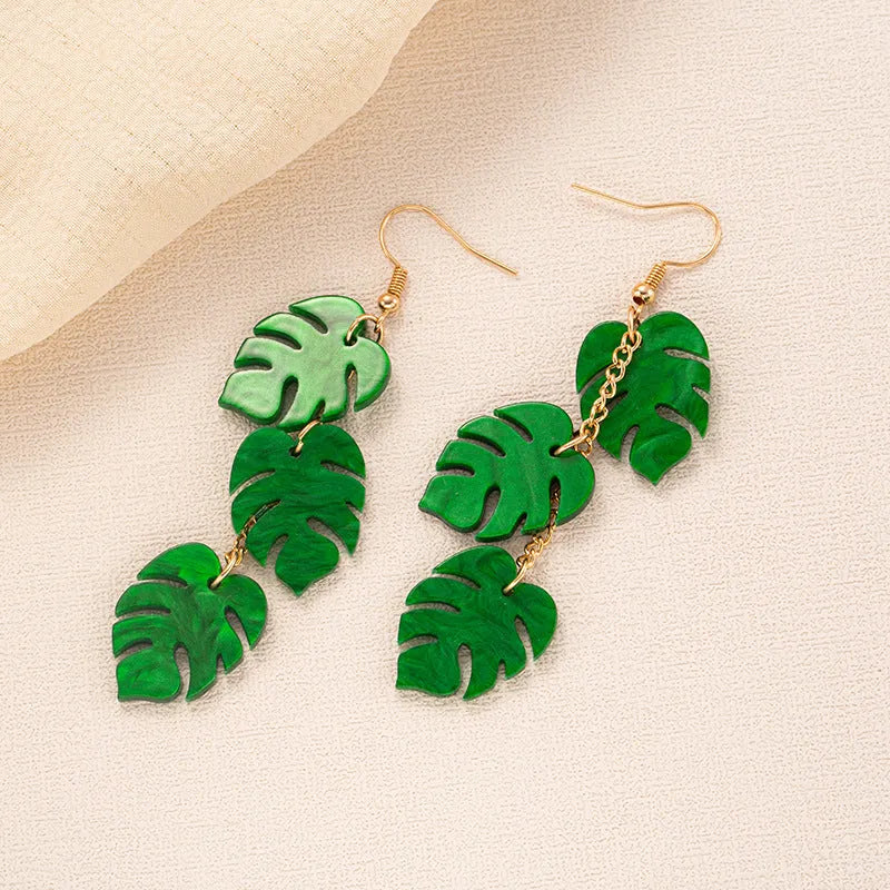A pair of drop-shaped acrylic earrings designed like coconut leaves, in one of five colour variations.