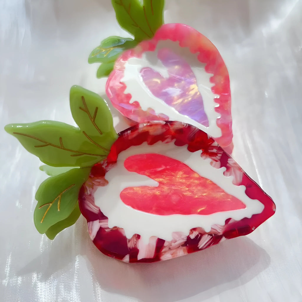 A red or pink hairpin featuring a sweet strawberry fruit design in a pastoral style.
