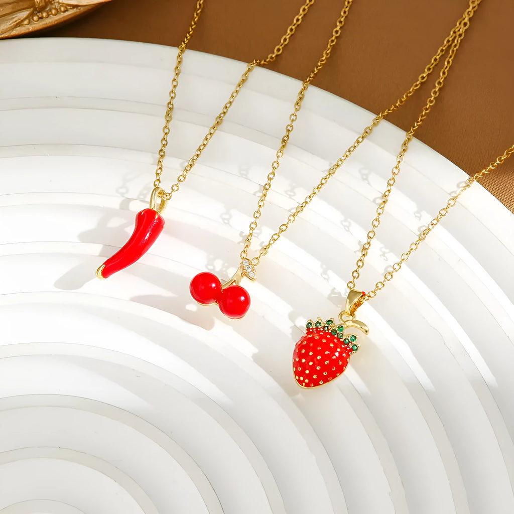 Close-up of a titanium steel necklace with an indie-style cherry pendant on an O-ring chain.