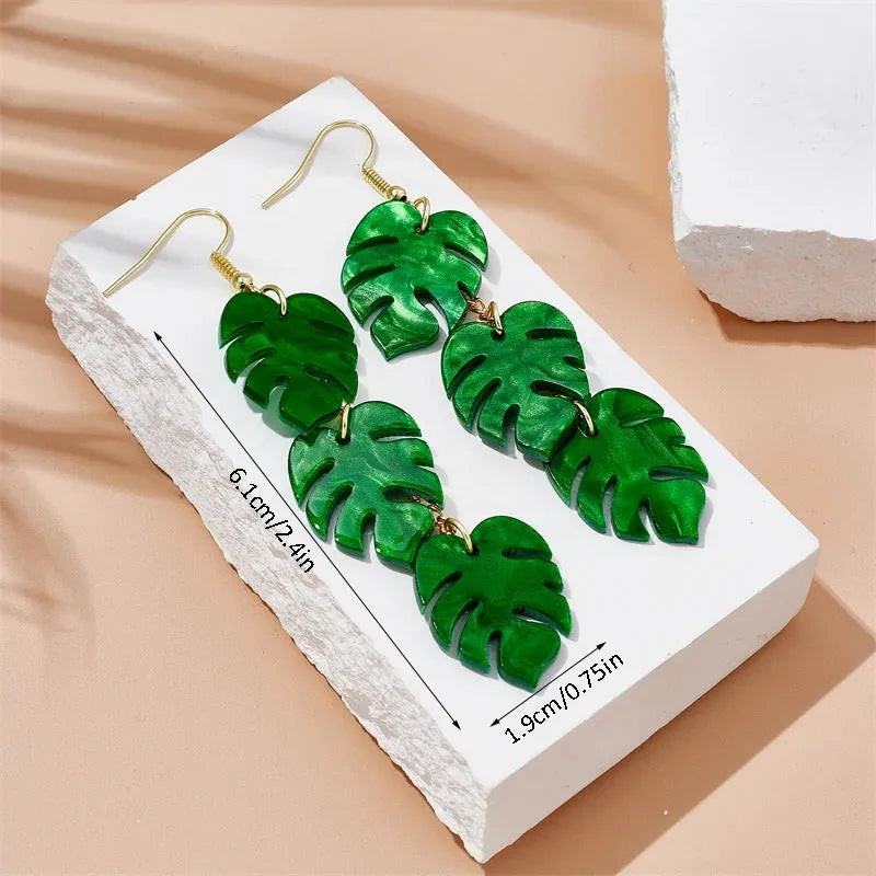 A pair of drop-shaped acrylic earrings designed like coconut leaves, in one of five colour variations.