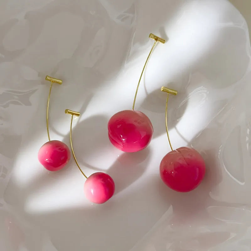 A pair of acrylic peach fruit earrings on copper posts, shown in small and large size options.