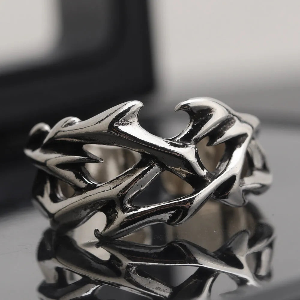 Copper adjustable ring with geometric thorn and flower design on a hand.