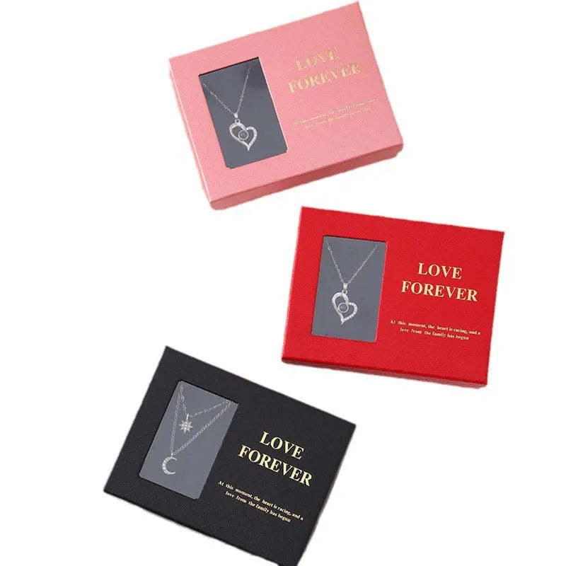 Red Korean-style jewellery gift box open to show six pink soap flowers, with a black handbag beside it.