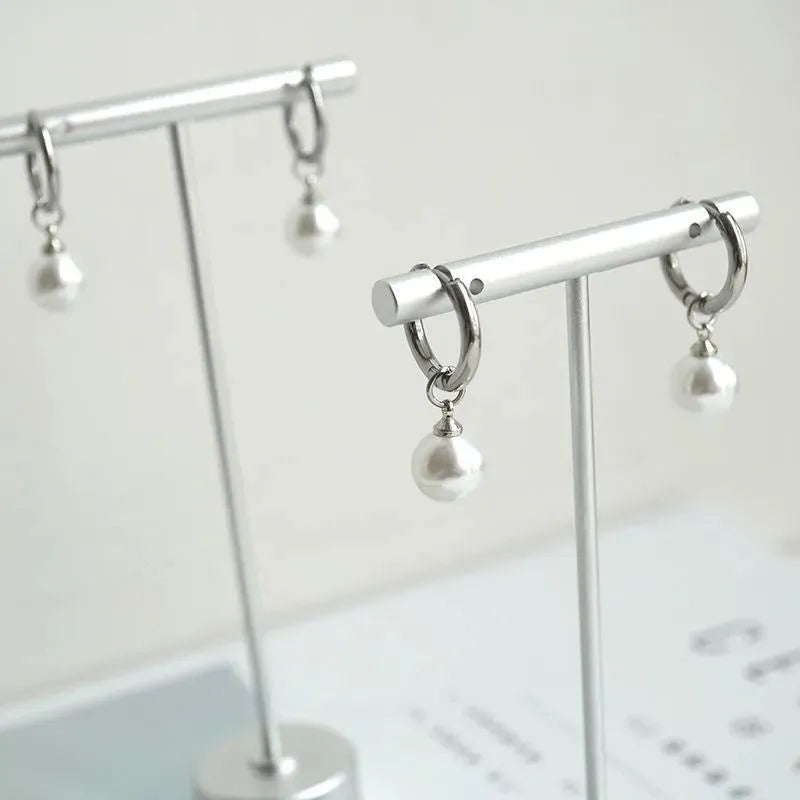 A pair of women's alloy earrings with a geometrical shape and a central round pearl.