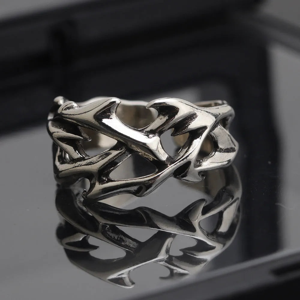 Copper adjustable ring with geometric thorn and flower design on a hand.