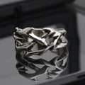 Copper adjustable ring with geometric thorn and flower design on a hand.