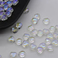 Twenty transparent love heart shaped spacer beads in assorted colours on a white background.