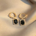 A pair of black geometric quadrilateral zircon earrings with a French Court retro design on a white background.