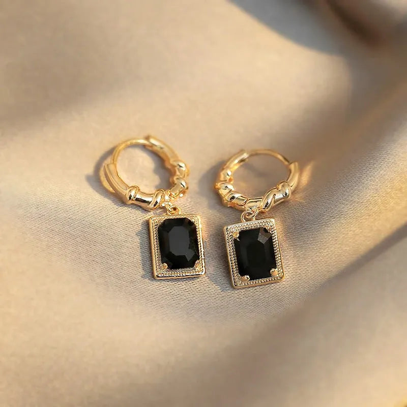 A pair of black geometric quadrilateral zircon earrings with a French Court retro design on a white background.