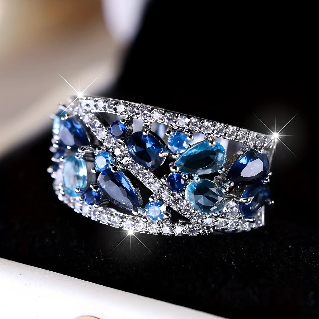Women's hollow round copper fashion ring with gemstone, shown in gold and platinum colour options.