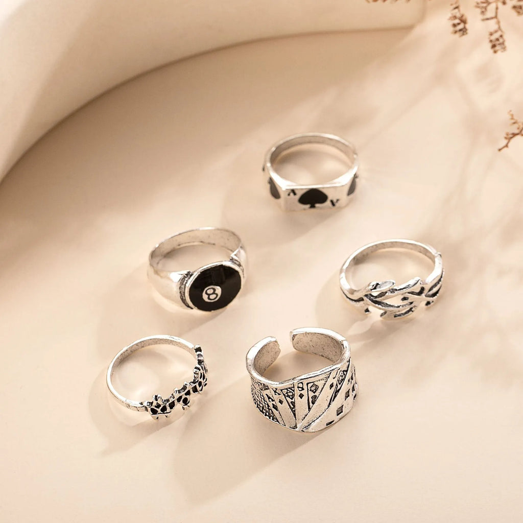 Black alloy poker ring with a retro spade card design on a finger.