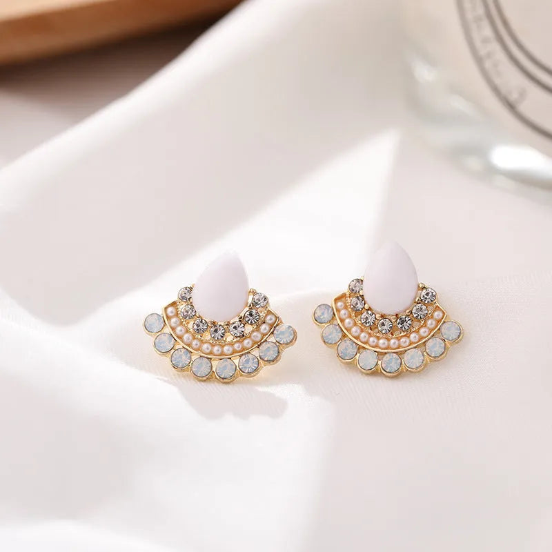 Women's silver geometric fan-shaped stud earrings with a central rhinestone on a white background.