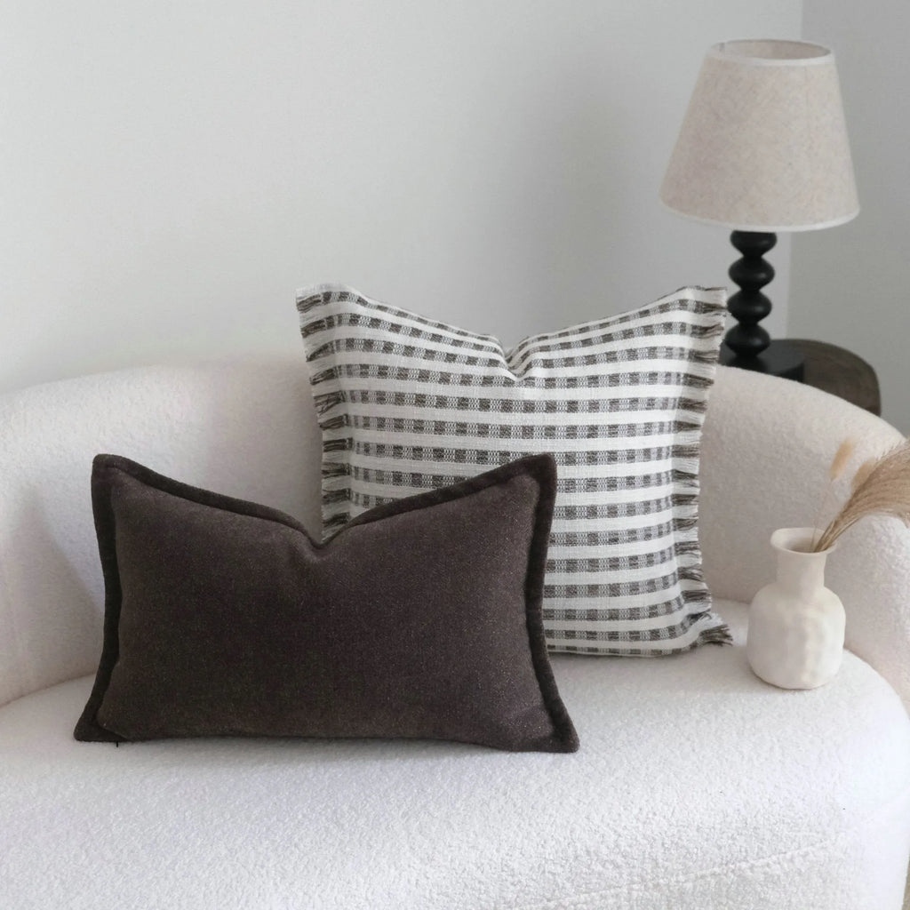 Coffee brown Chinese classical style cushion with striped and patchwork designs on a sofa.