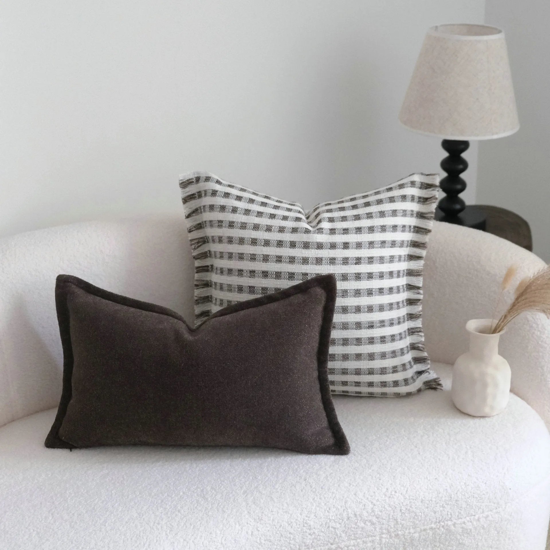 Coffee brown Chinese classical style cushion with striped and patchwork designs on a sofa.