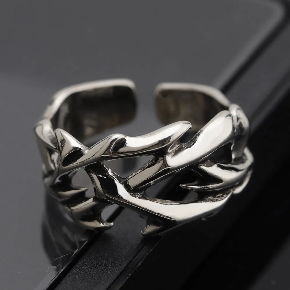 Copper adjustable ring with geometric thorn and flower design on a hand.