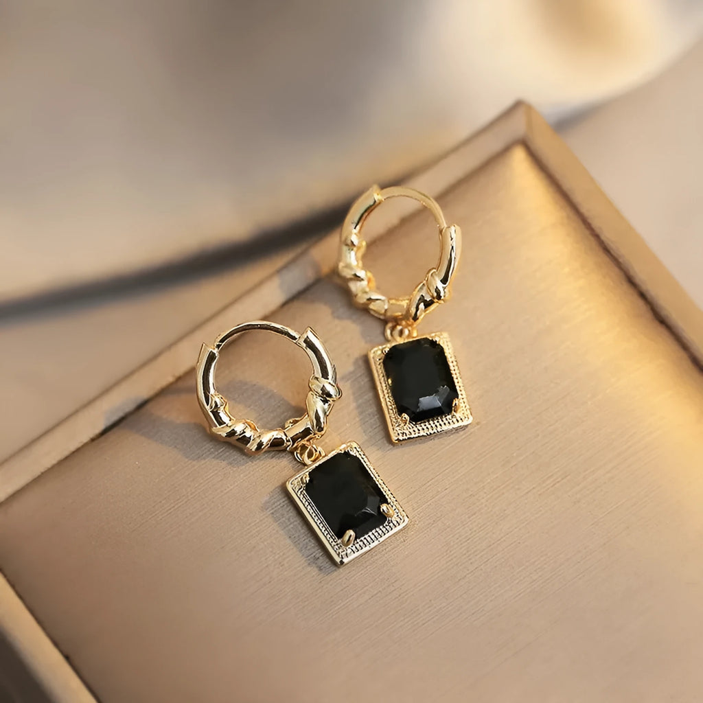 A pair of black geometric quadrilateral zircon earrings with a French Court retro design on a white background.