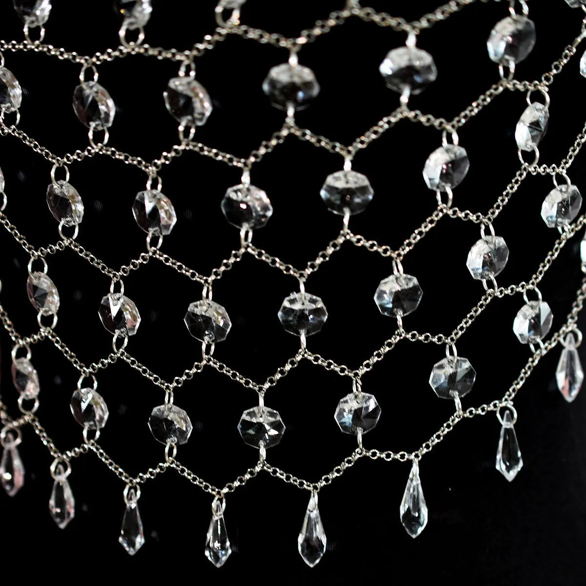 Hand-woven transparent acrylic sequinned plastic resin body chain draped flat.