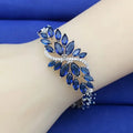 Gold electroplated copper bracelet with ice flower design and blue zircon stones
