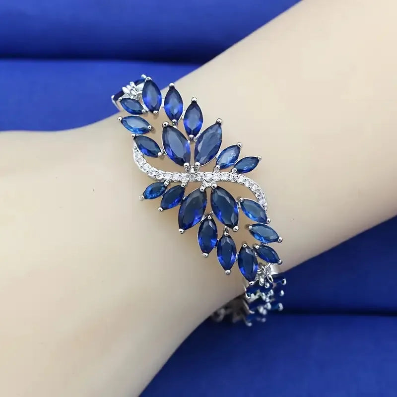 Gold electroplated copper bracelet with ice flower design and blue zircon stones