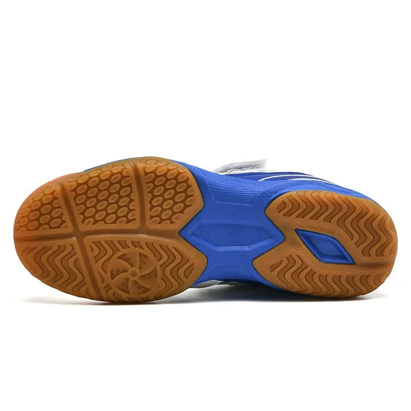 Lightweight white and blue badminton shoes with ribbed sole on an indoor court.