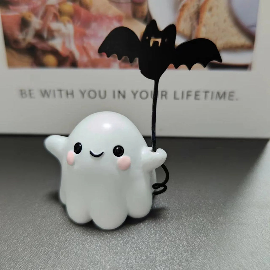 Small resin statue of an American-style ghost walking a dog and holding a bat.